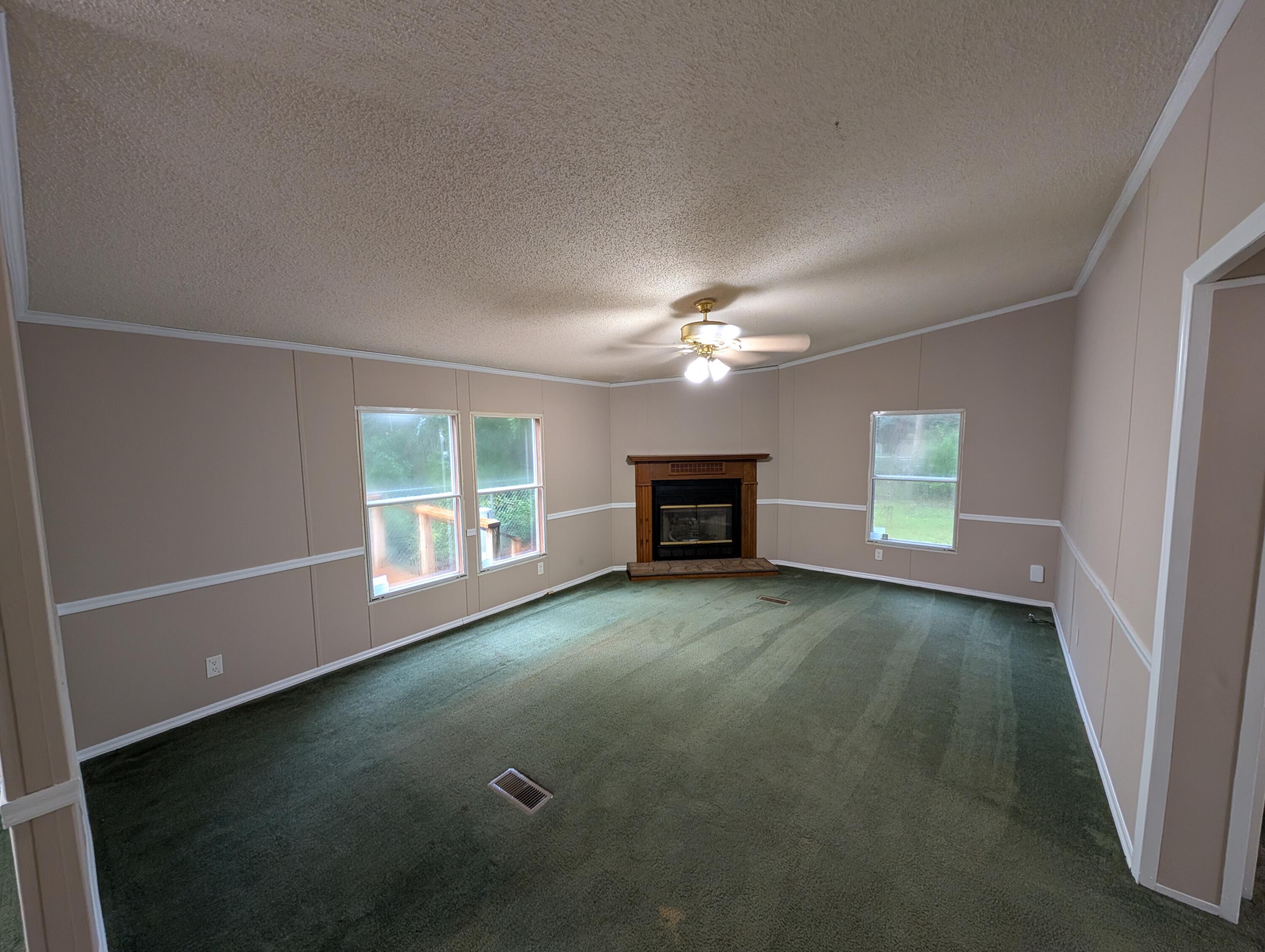 157 East Harborview Road Santa Rosa Beach, FL 32459 - Photo 9 of 27 an empty room with windows and fireplace