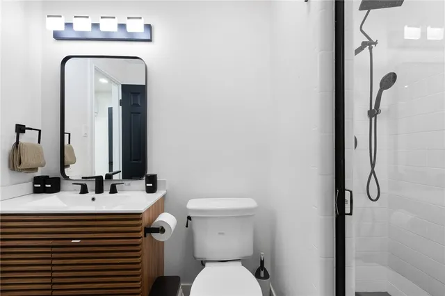 a bathroom with a sink a toilet and shower