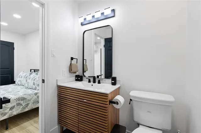 a bathroom with a sink toilet and mirror