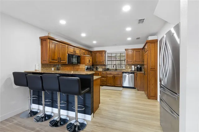 a kitchen with granite countertop wooden cabinets and stainless steel appliances