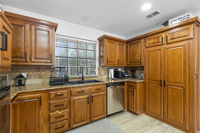 a kitchen with stainless steel appliances granite countertop a refrigerator and cabinets