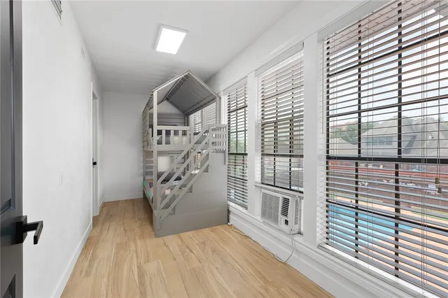 wooden floor in a room next to a large window