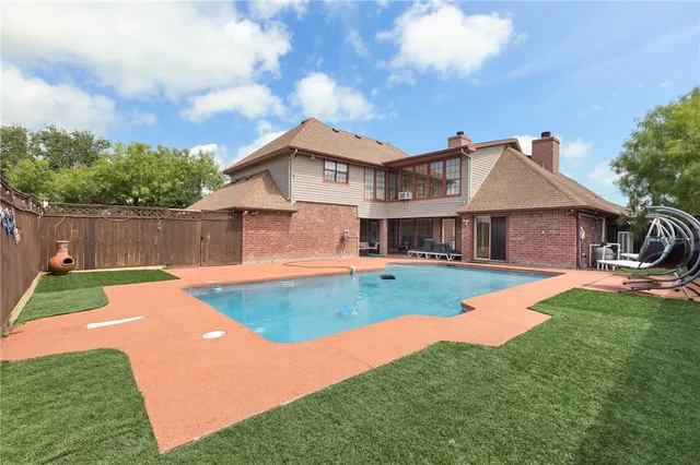 a view of a backyard with swimming pool and seating space