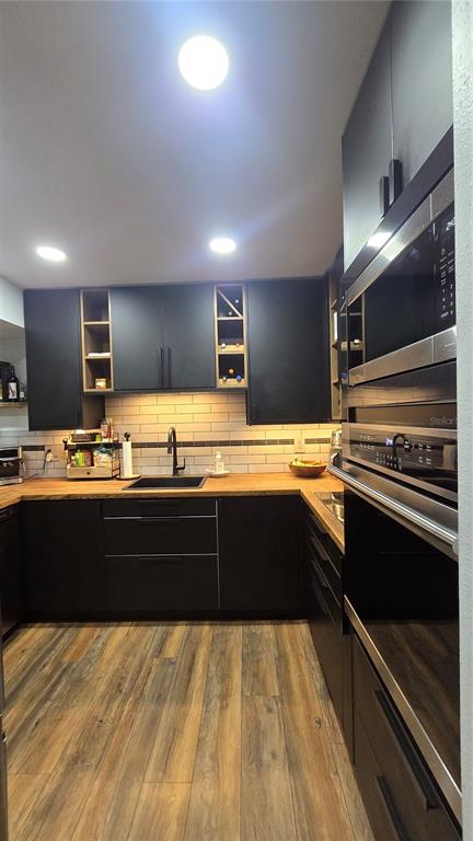 406 Lennox Road West Palm Harbor, FL 34683 - Photo 11 of 40 a kitchen with stainless steel appliances kitchen island granite countertop a stove and a sink