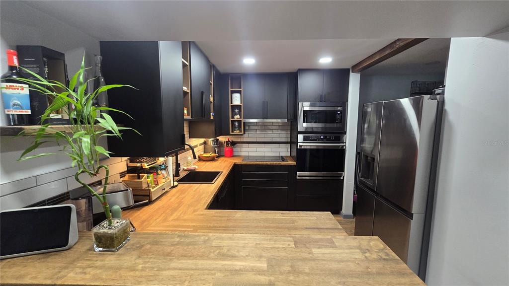 406 Lennox Road West Palm Harbor, FL 34683 - Photo 8 of 40 a kitchen with stainless steel appliances kitchen island granite countertop a refrigerator a stove and a sink