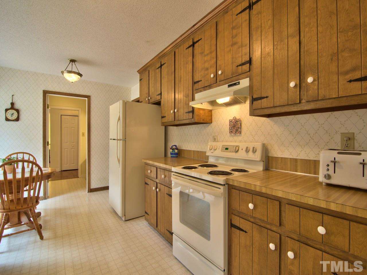 5701 Geoffrey Road Durham, NC 27712 - Photo 19 of 23 a kitchen with stainless steel appliances granite countertop a stove a refrigerator and a cabinets