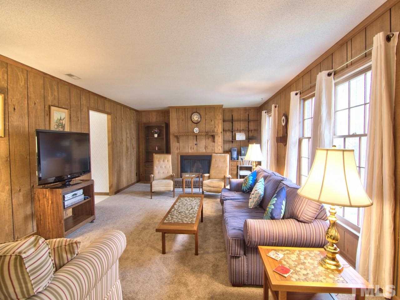 5701 Geoffrey Road Durham, NC 27712 - Photo 5 of 23 a living room with furniture a flat screen tv and a large window