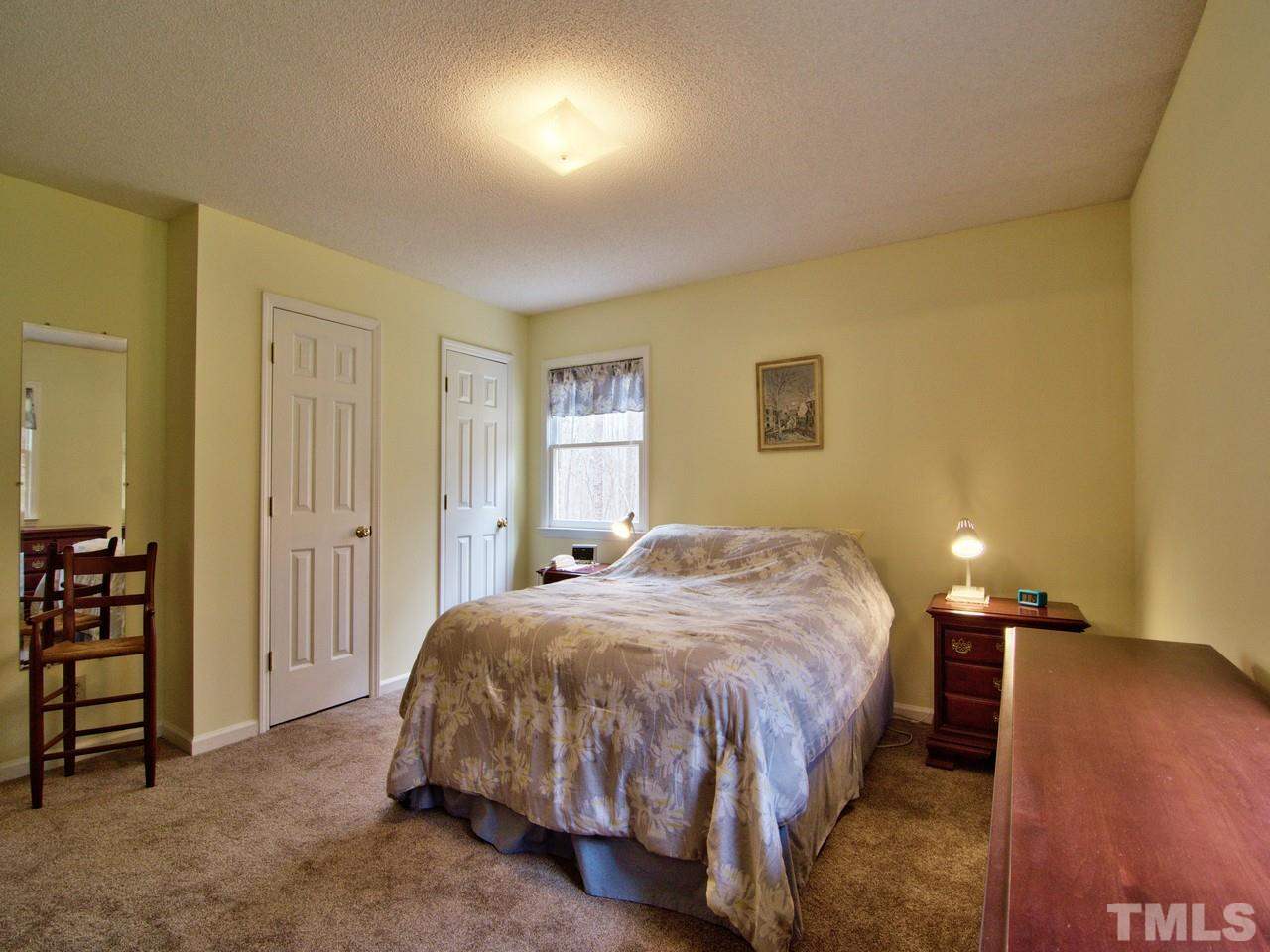 5701 Geoffrey Road Durham, NC 27712 - Photo 8 of 23 a bedroom with a bed and a lamp