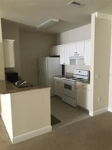 a kitchen with cabinets a sink and white stainless steel appliances