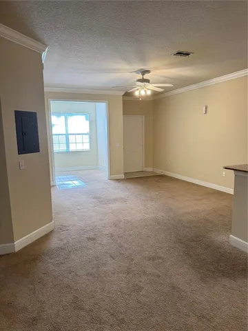 en empty room with windows and ceiling fan