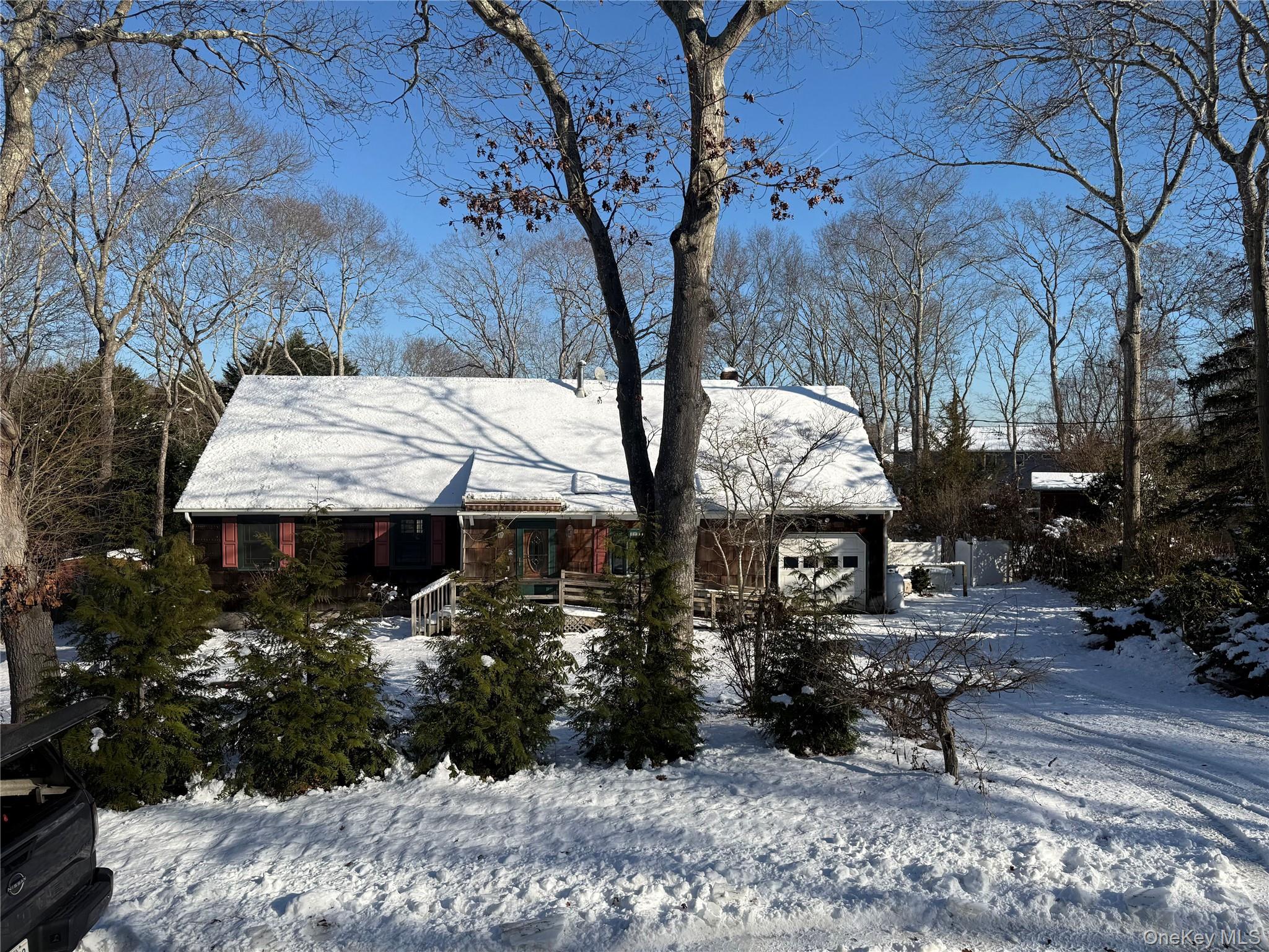 3 Fairview Road Hampton Bays, NY 11946 - Photo 2 of 3 View of front of home featuring a chimney, a garage, and a porch
