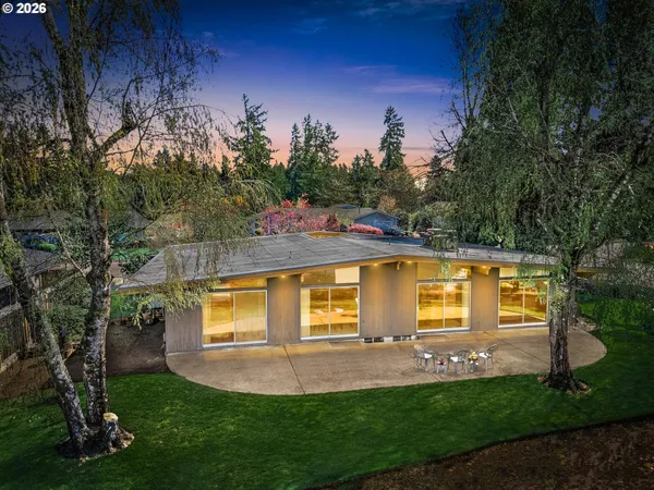 a view of a house with backyard and a tree
