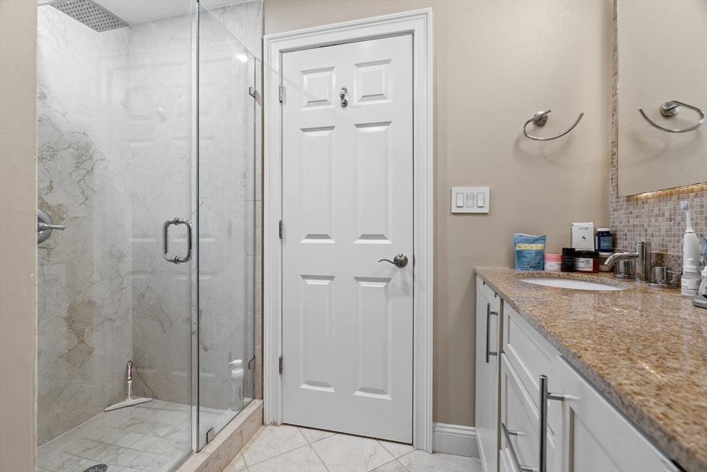 98 Waltham Street, Unit 1 Boston, MA 02118 - Photo 12 of 26 a bathroom with a granite countertop shower mirror and a sink