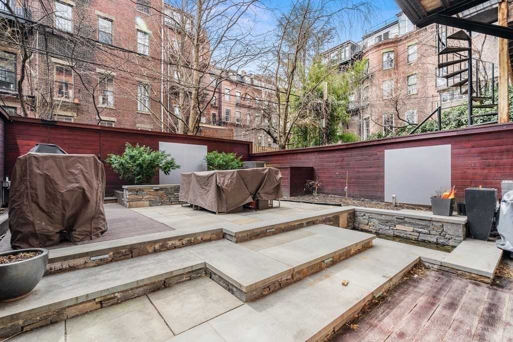 98 Waltham Street, Unit 1 Boston, MA 02118 - Photo 24 of 26 a view of a patio with table and chairs and potted plants