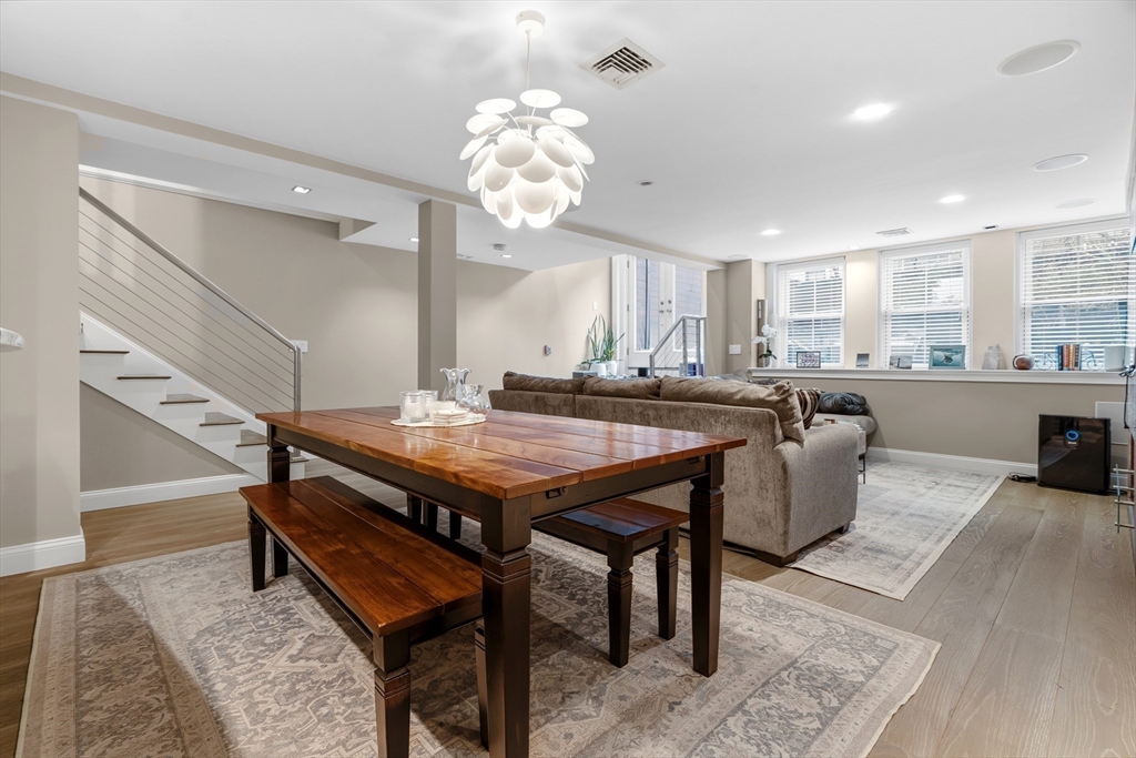 98 Waltham Street, Unit 1 Boston, MA 02118 - Photo 7 of 26 a dining hall with stainless steel appliances kitchen island granite countertop furniture and wooden floor
