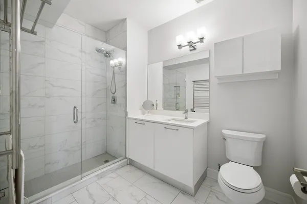 a bathroom with a toilet a sink a mirror and vanity