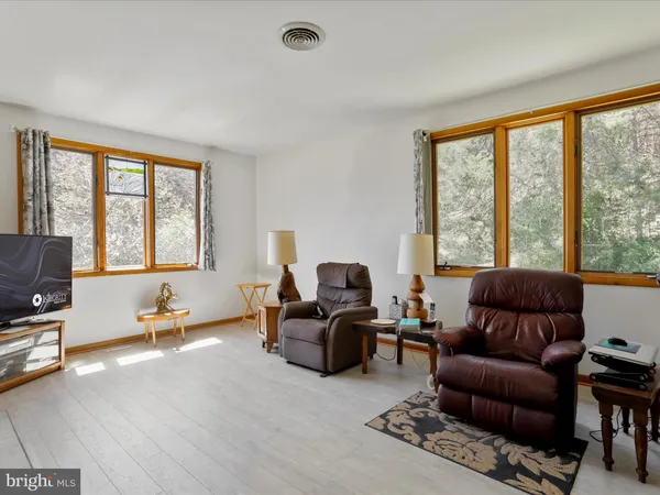 a living room with furniture and floor to ceiling windows