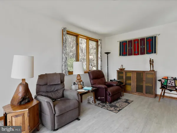 a living room with furniture and a flat screen tv with wooden floor