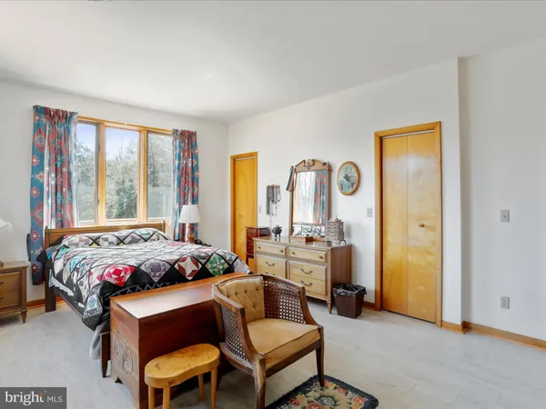 a bedroom with a bed and large windows