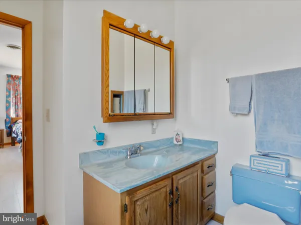 a bathroom with a granite countertop sink and a toilet