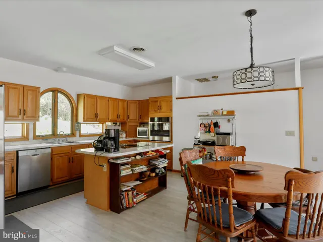 a kitchen with a stove a refrigerator and a dining table