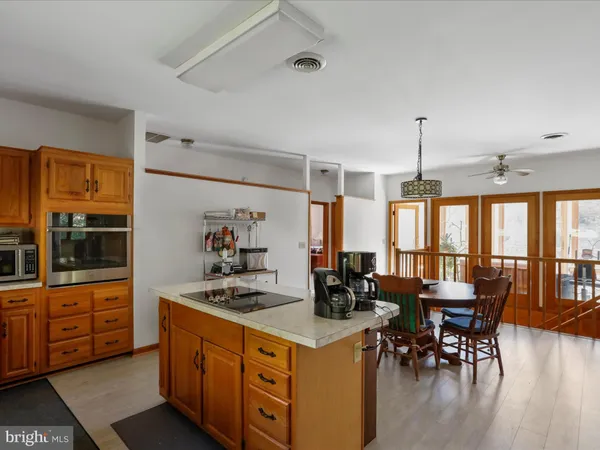 a kitchen with stainless steel appliances granite countertop a stove and a dining table with wooden floor