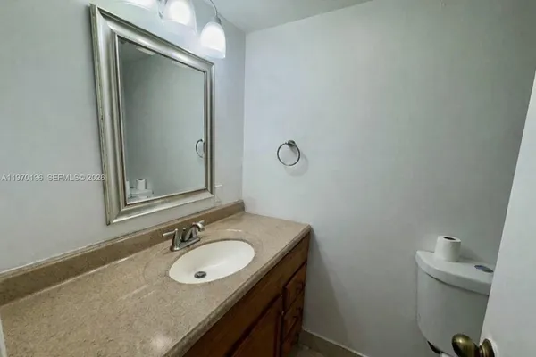 a bathroom with a granite countertop sink and a mirror