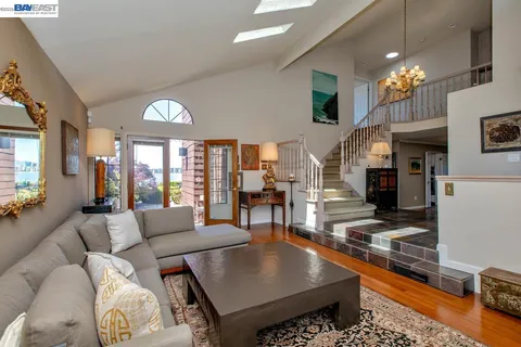 a dining room with wooden floor a chandelier a wooden table and chairs