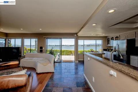 a living room with furniture a rug and a floor to ceiling window