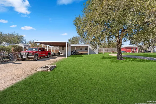 a view of a house with a big yard and sitting area