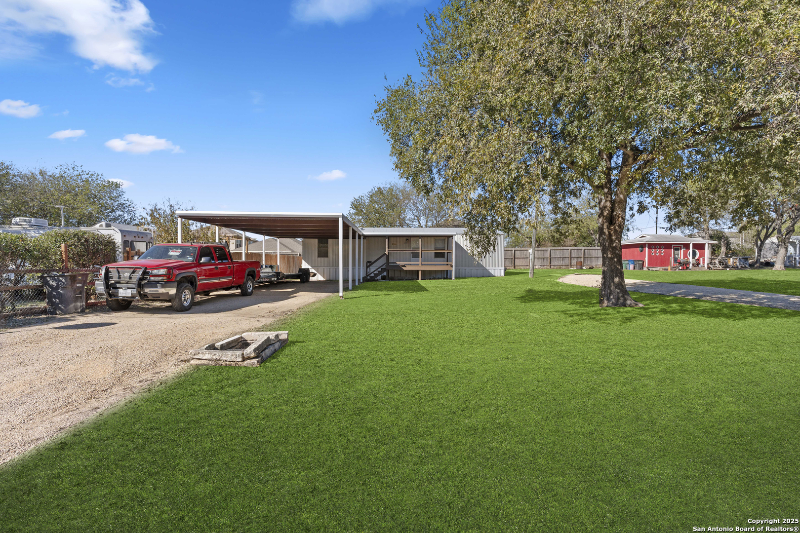 a view of a house with a big yard and sitting area