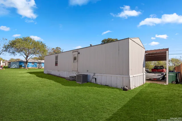 a view of a backyard with potted plants and large tree