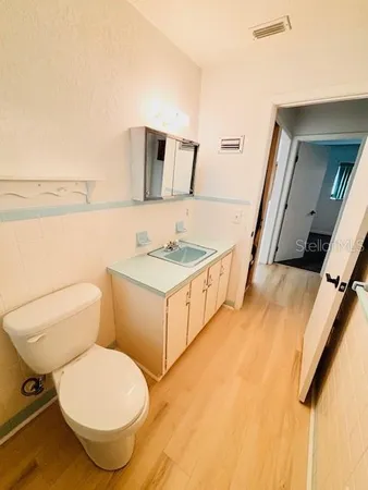 a bathroom with a toilet sink and mirror