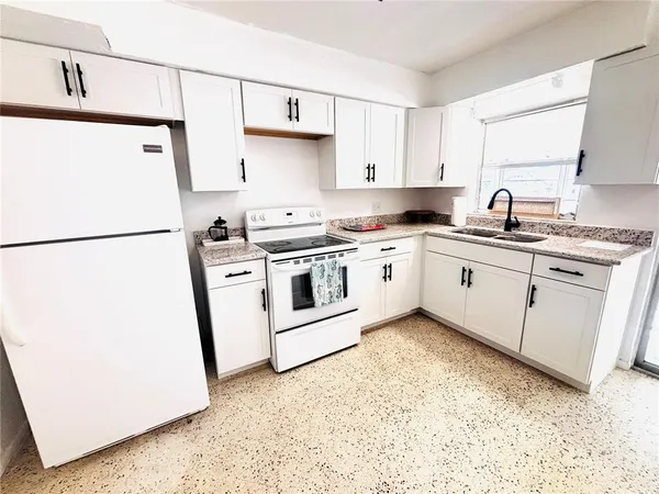 a kitchen with stainless steel appliances granite countertop a sink stove a refrigerator and cabinets