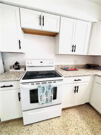 a white stove top oven sitting inside of a kitchen