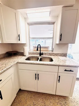 a kitchen with granite countertop a sink and a stove