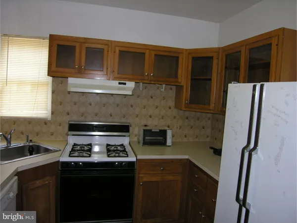 a kitchen with a refrigerator and a stove top oven