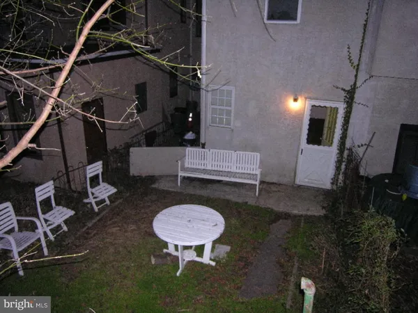 a view of an outdoor sitting area in back of a house