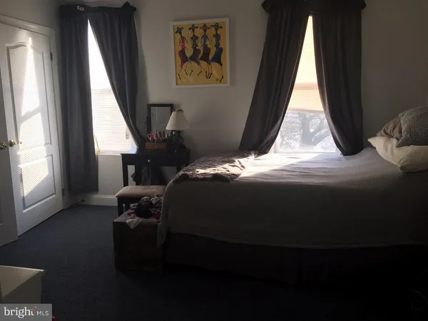 a bedroom with a bed next to a window