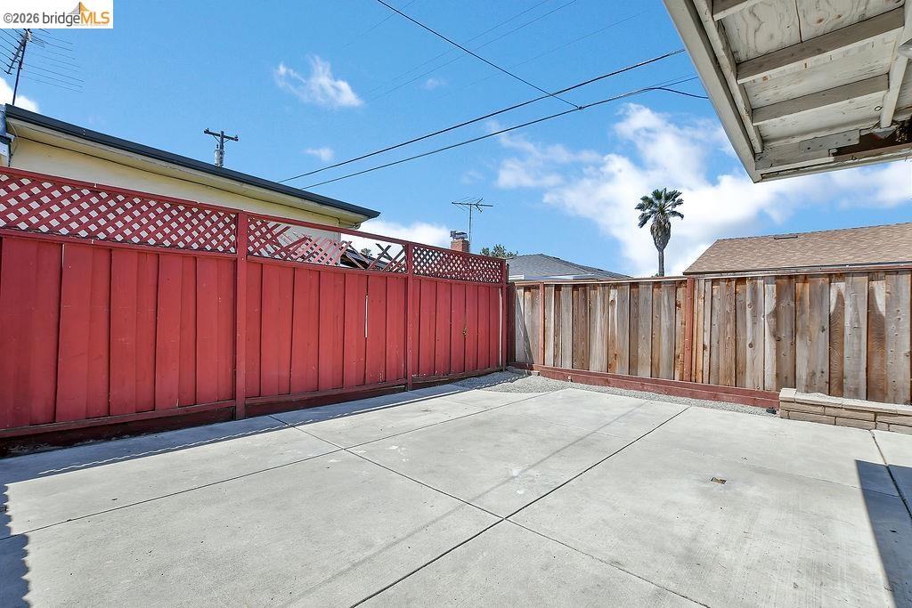 805 Calero Street Milpitas, CA 95035 - Photo 18 of 23 Concrete patio area featuring a red lattice-top privacy fence and natural wood fencing