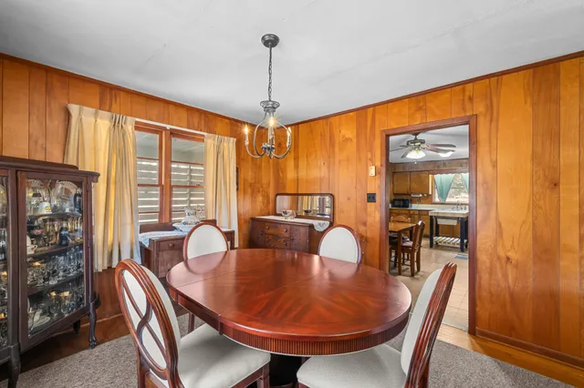 a kitchen with stainless steel appliances a dining table chairs stove refrigerator and cabinets