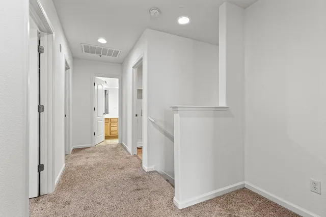 a view of a hallway with wooden floor and closet