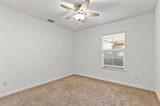 a spacious bathroom with a granite countertop sink a toilet and a mirror