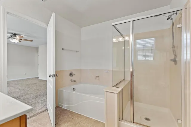 a view of a big room with chandelier fan and windows