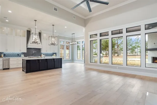 a large kitchen with stainless steel appliances granite countertop a large counter top and a chandelier