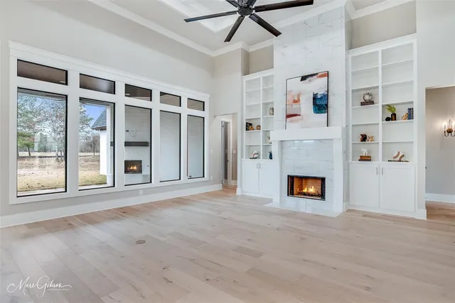 a view of an empty room with window and fire place