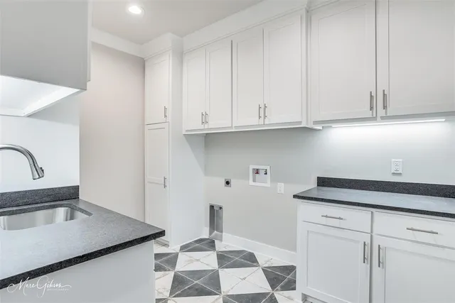 a kitchen with stainless steel appliances granite countertop a sink a stove and white cabinets