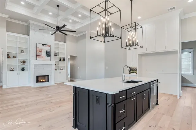 a kitchen with cabinets a center island and wooden floor