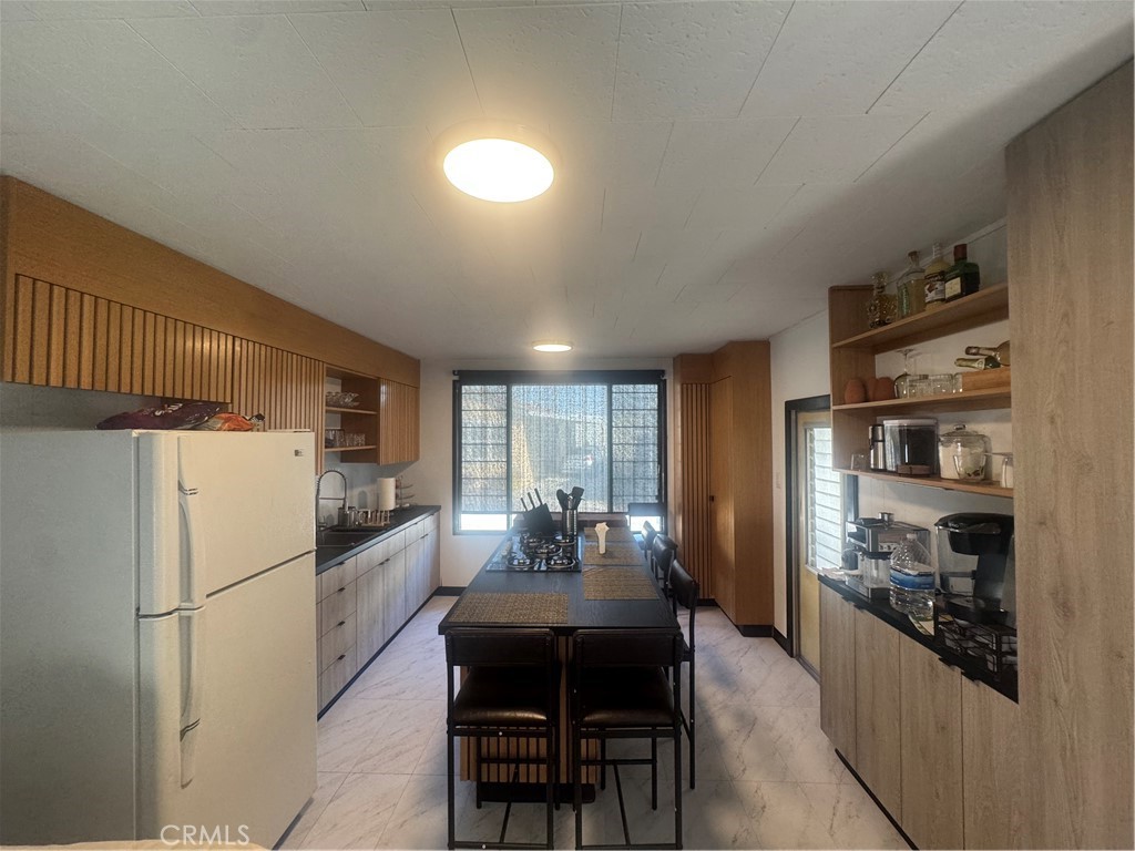 47 Fir Via Anaheim, CA 92801 - Photo 3 of 14 a kitchen with refrigerator a table and chairs