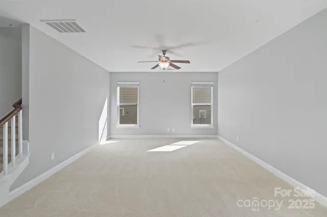 a kitchen with stainless steel appliances granite countertop a stove a sink a refrigerator and white cabinets with wooden floor